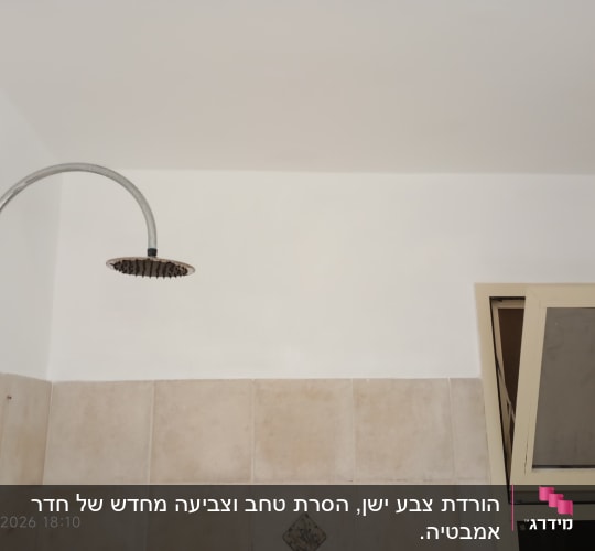 קיר צבוע עם מקלחת וחלון פתוח